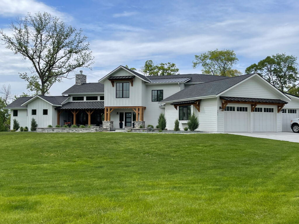 A large, white hose with a well manicured lawn.